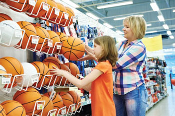 Woman and child selecting basketballs from a store display
